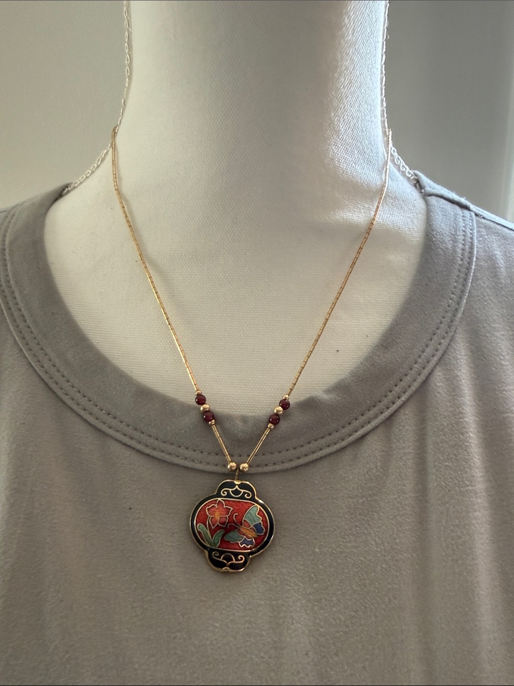 decorative necklace featuring a colorful cloisonné butterfly and floral pendant